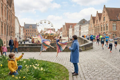 Scène de rue animée d'une ville européenne au printemps : ballerines, coureurs, enfant et grande roue, sous un ciel nuageux.
