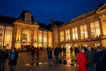 Palais des Beaux-Arts de Lille illuminé la nuit avec des visiteurs déambulant sur le parvis pavé lors de la nocturne.
