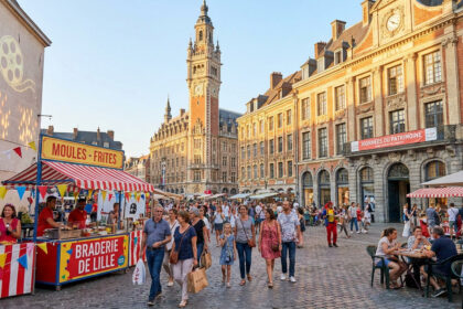 Foule animée à Lille lors de la célèbre Braderie, avec des stands de moules-frites et l'architecture historique en fond.