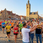 Des coureurs et des spectateurs trinquent avec des bières lors du Marathon de la bière des Flandres.